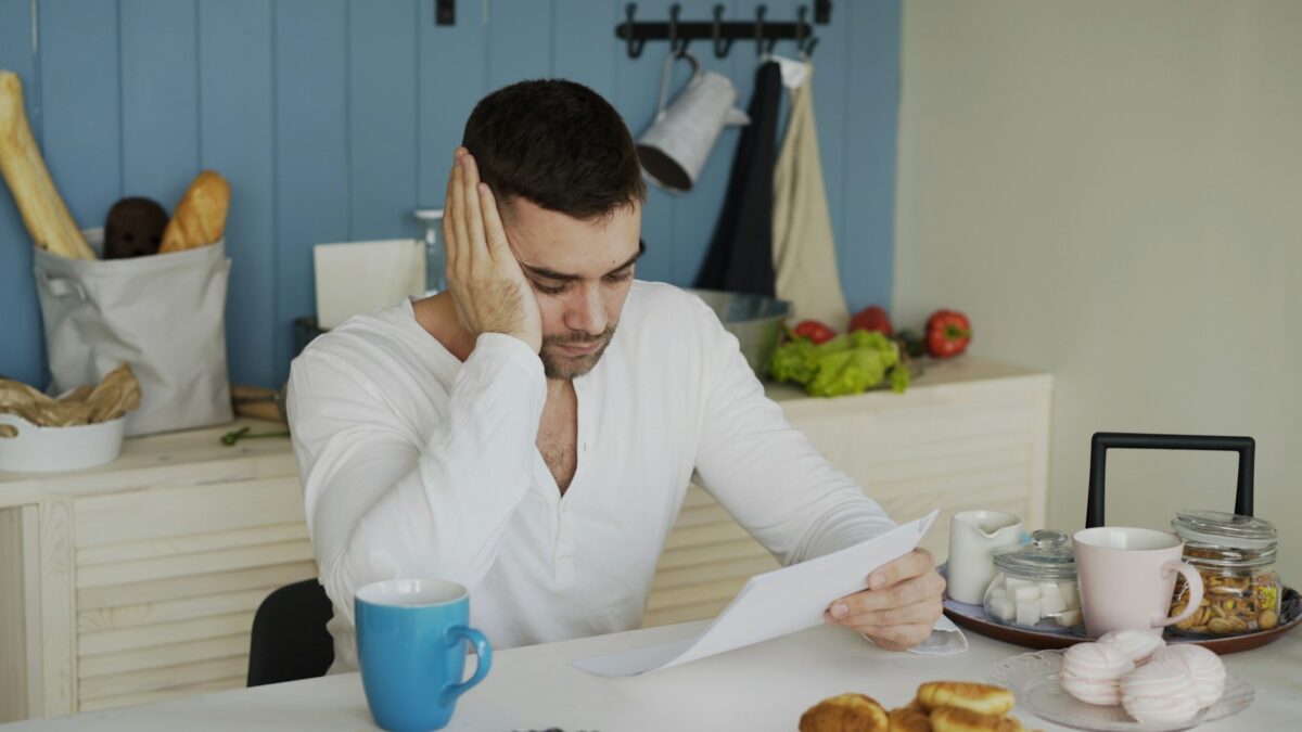 Consumer reading financial documents at home