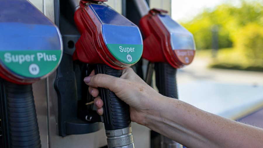 person holding high fuel pump price sign