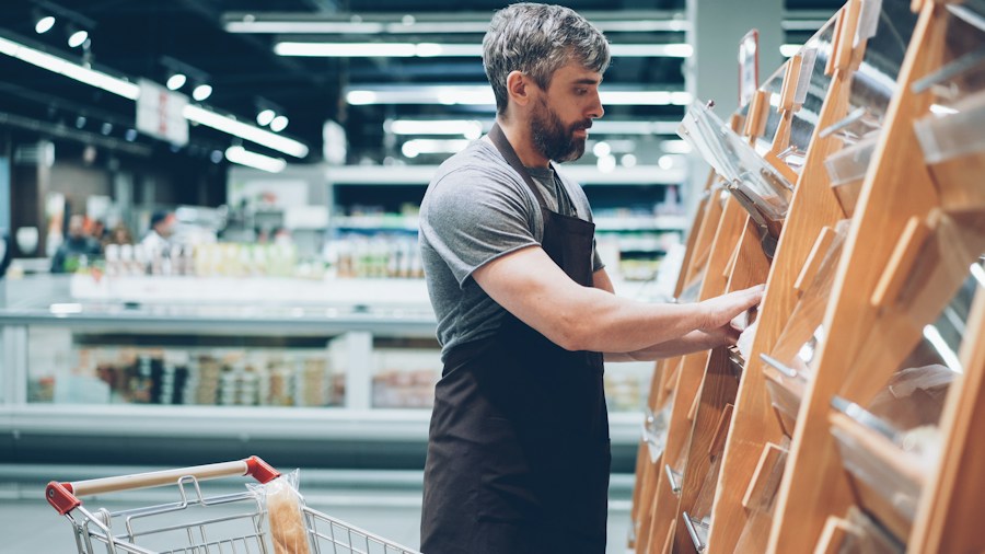 supermarket employee restocking shelves midnight